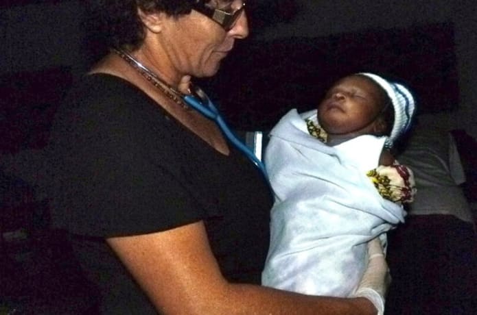 New born child being held by Nurse Raquel Shafer.